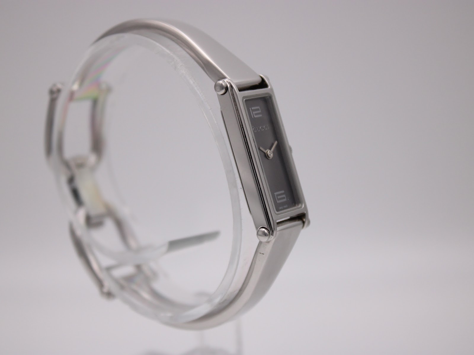 Another side-angle view of the Gucci 1500 L watch, highlighting the sleek design of the integrated stainless steel bracelet.