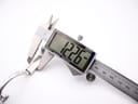 Digital caliper measuring the case width of the Gucci 1500 L watch, displaying a precise measurement of 12.26mm.