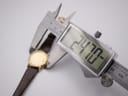 Digital caliper measuring the watch case diameter, displaying a precise measurement of 24.70mm.