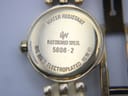 Close-up of the watch's case back, clearly showing "Raymond Weil Geneve 5806-2", "Water Resistant 10 M", and "18K Gold Electroplated".
