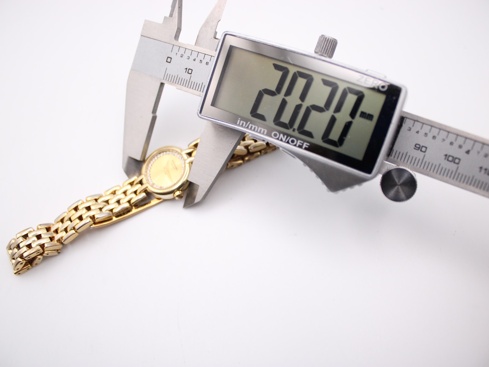 Digital caliper measuring the case diameter of the Raymond Weil watch, displaying a precise reading of 20.20mm.