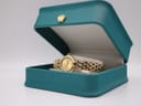 The Raymond Weil watch presented within its original teal-coloured Raymond Weil box with a golden crown emblem.