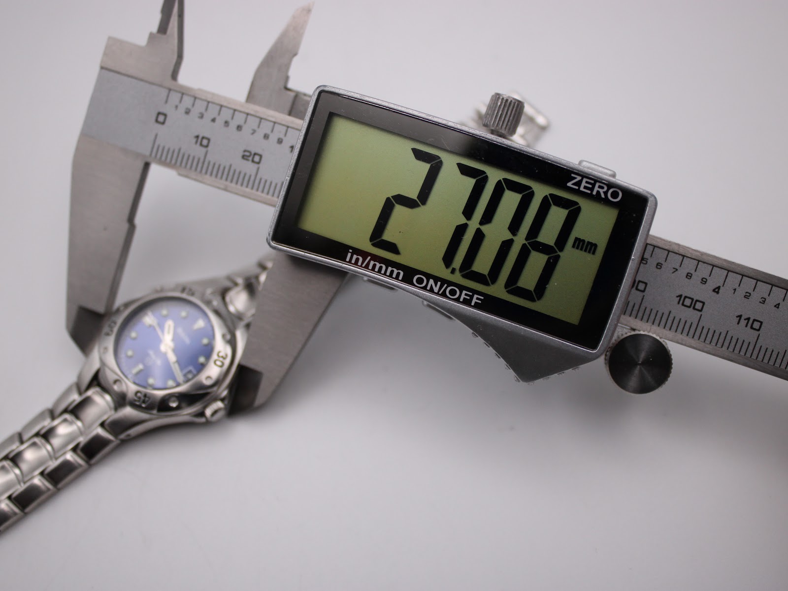 Digital caliper measuring the case diameter of the Bulova Marine Star watch, displaying 27.08 mm on screen.