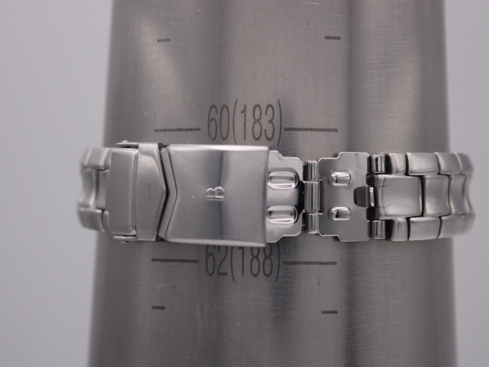 The watch bracelet clasped around a metal wrist sizing gauge, showing the maximum wrist circumference reading of approximately 17.2cm (57mm diameter).