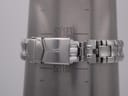 The watch bracelet clasped around a metal wrist sizing gauge, showing the maximum wrist circumference reading of approximately 17.2cm (57mm diameter).