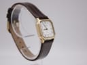 Angled side view of the Tissot 21589 watch on a stand, highlighting the slim profile and brown leather strap.