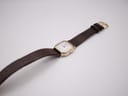 Overhead view of the Tissot 21589 watch with its brown crocodile-grain leather strap and gold-coloured buckle.