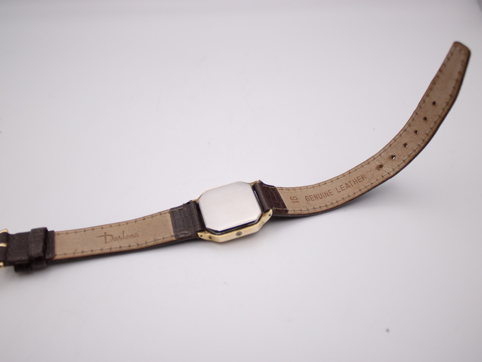 Close-up of the underside of the brown leather strap, showing 'GENUINE LEATHER' and 'Darlona' markings.