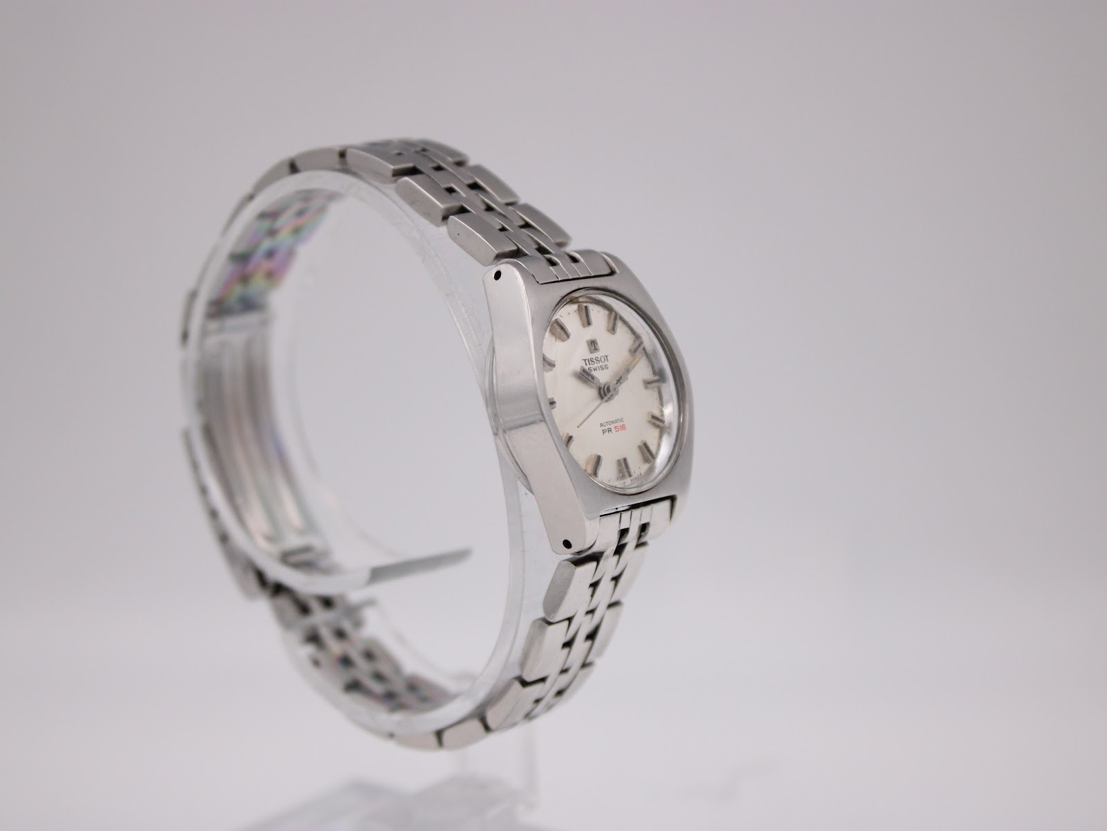 Another angled side view of the Tissot PR 516, highlighting the case profile and integrated bracelet.