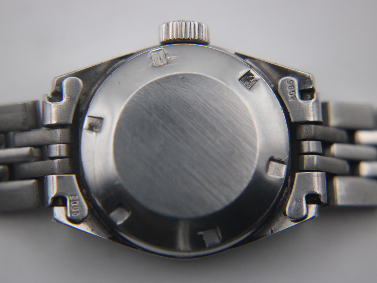 Close-up of the plain brushed stainless steel case back of the Tissot PR 516 watch.