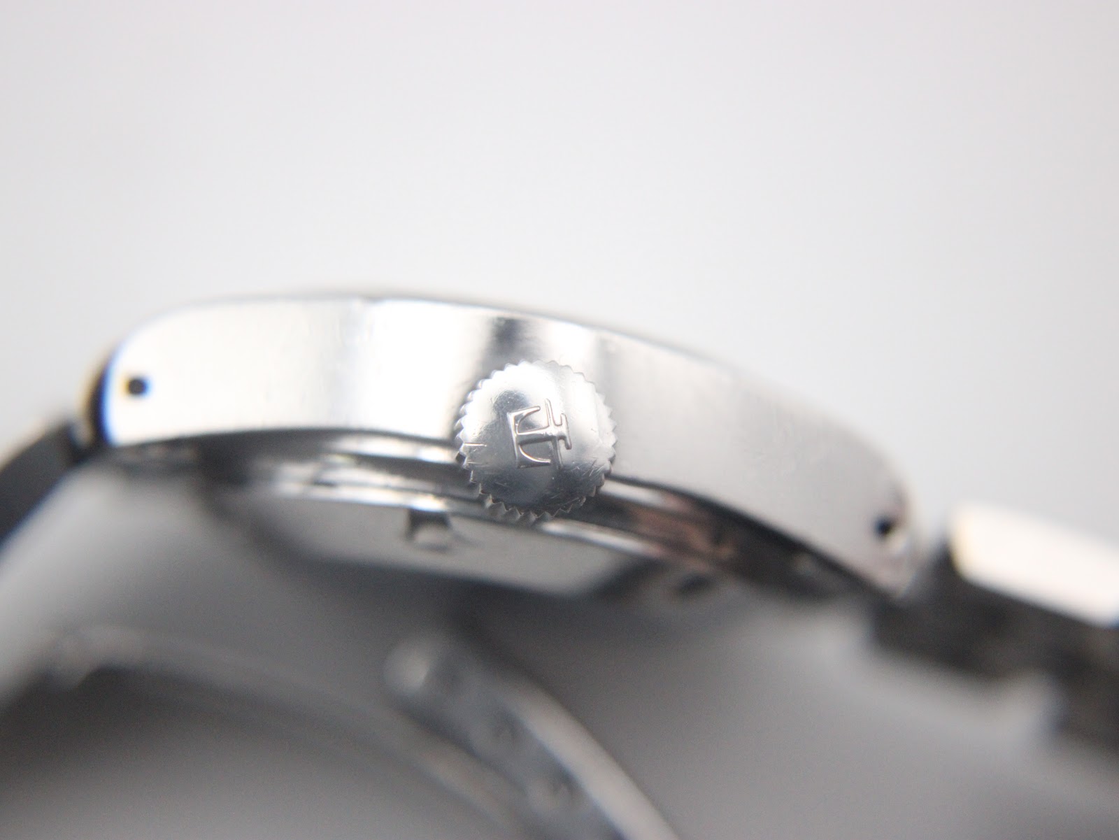 Close-up of the crown, showing the detailed Tissot 'T' logo.