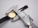 Overhead shot of the Continental watch case being measured by a digital caliper, displaying a precise diameter of 32.49mm.