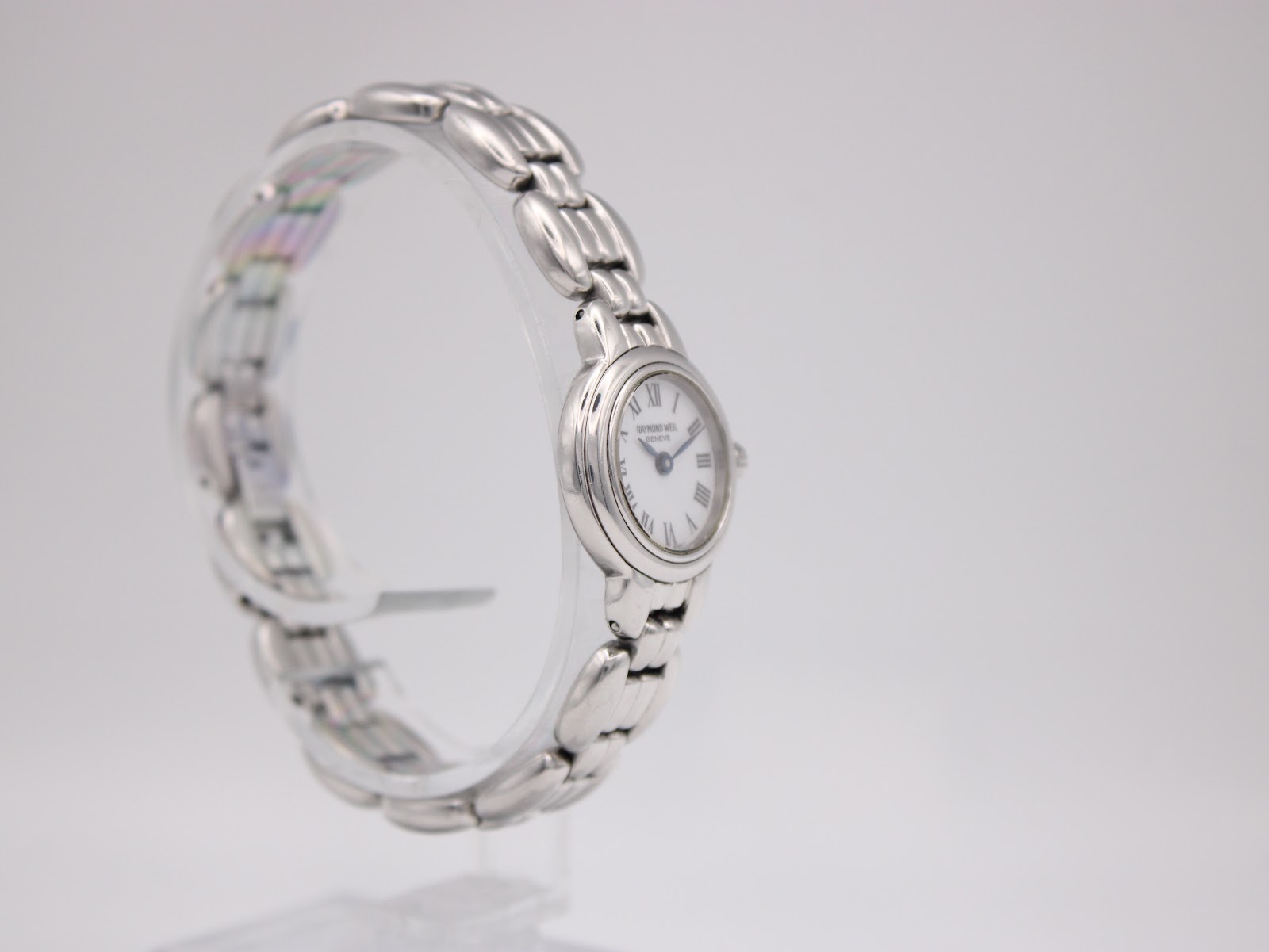 Right angled view of the Raymond Weil 5830 watch, highlighting the crown and the curve of the integrated bracelet.
