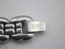 Close-up of the Raymond Weil watch's stainless steel fold-over clasp, clearly showing the engraved 'RW' logo.