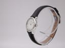 Angled side view of the Tissot C226K watch on a transparent display stand, showing the crown and case profile.