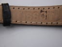 Close-up of the inner side of the black leather strap, showing light wear and stitch detailing.