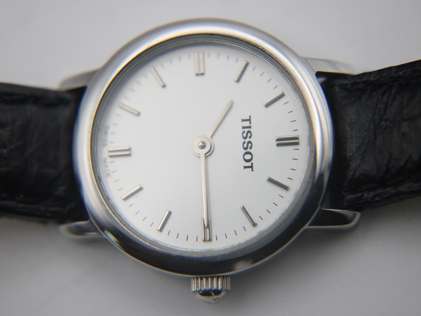 Macro close-up of the Tissot C226K's white dial, highlighting the applied baton indices, minute track, and 'SWISS MADE' text at the bottom.
