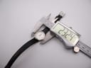Overhead shot of the Tissot C226K watch being measured by a digital caliper, displaying a case diameter of 23.24mm.