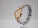 Angled view of the Bulova two-tone watch, showing the case and bracelet links on a clear stand.