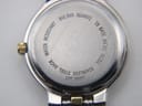 Close-up of the watch case back, engraved with "Bulova Quartz Water Resistant T8 Base Metal Bezel Stainless Steel Back Japan Mvt".