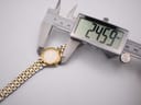 Digital caliper measuring the watch case, displaying a precise diameter of 24.59 mm.
