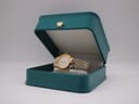 The Bulova watch resting inside an open green presentation box with a gold crown emblem.