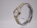 Angled side view of the Seiko watch on a display stand, showing the crown and integrated two-tone bracelet.