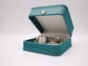 The Seiko watch displayed in a generic teal watch box with a gold crown emblem.