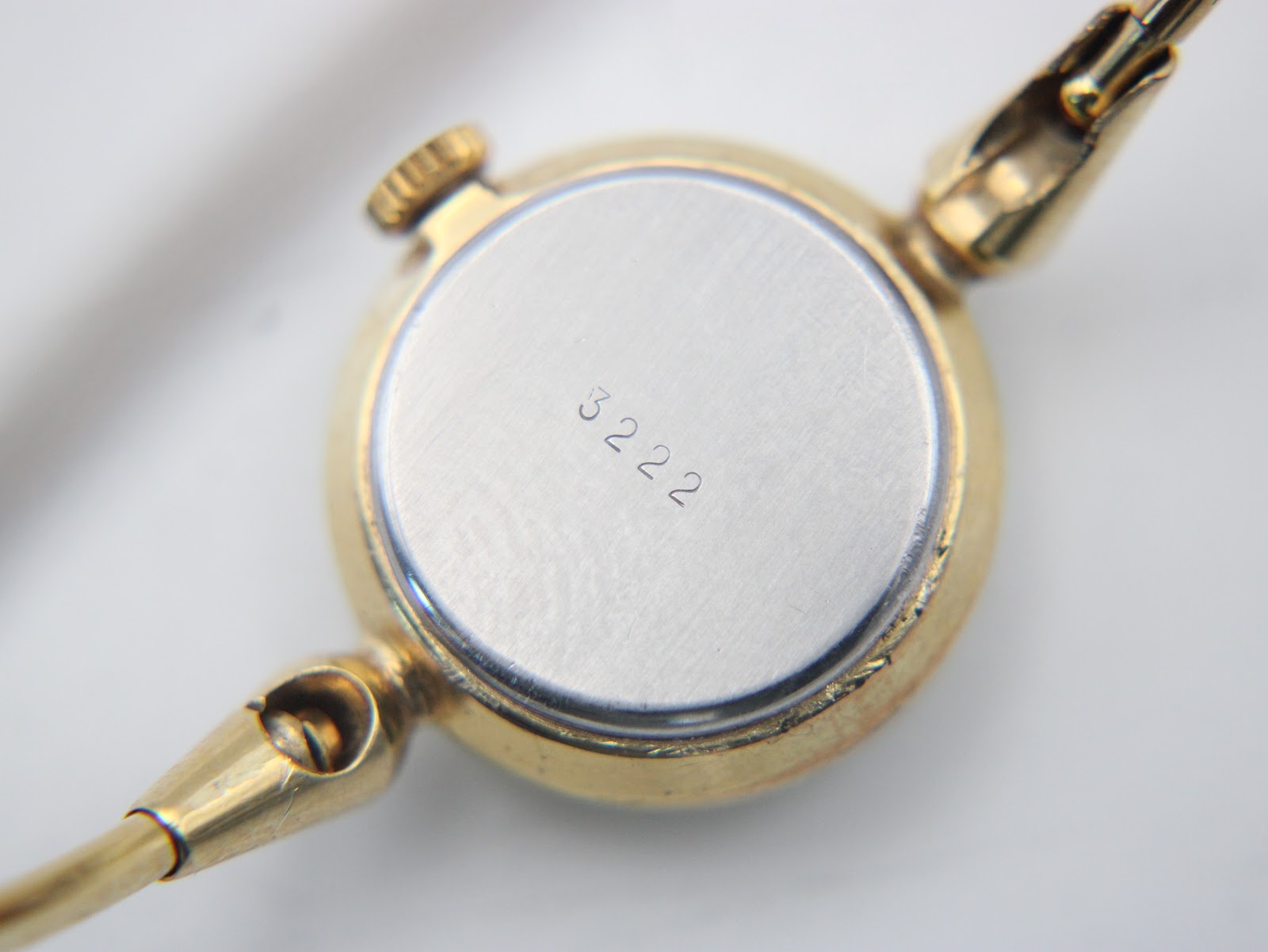 Close-up of the watch case back, showing the serial number "3222" engraved on the brushed stainless steel.