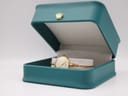 The Michel Herbelin watch placed inside a teal display box with a small gold crown emblem on the lid.
