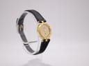 Side view of the Westar gold-toned watch showing the black leather strap and buckle on a display stand.