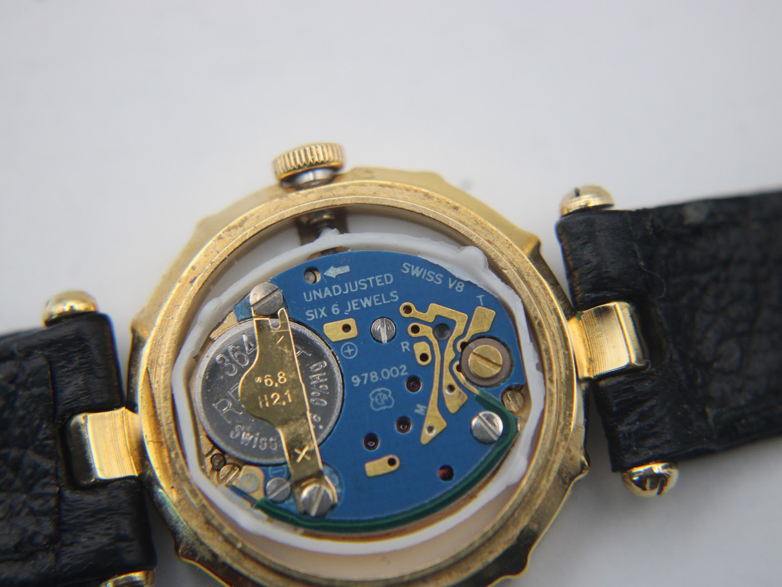 Detailed view of the Swiss quartz movement inside the Westar watch, showing the battery and jewels.