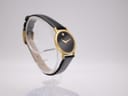 Another angled view of the watch, highlighting its slim profile and the simple gold-tone buckle on the black strap.