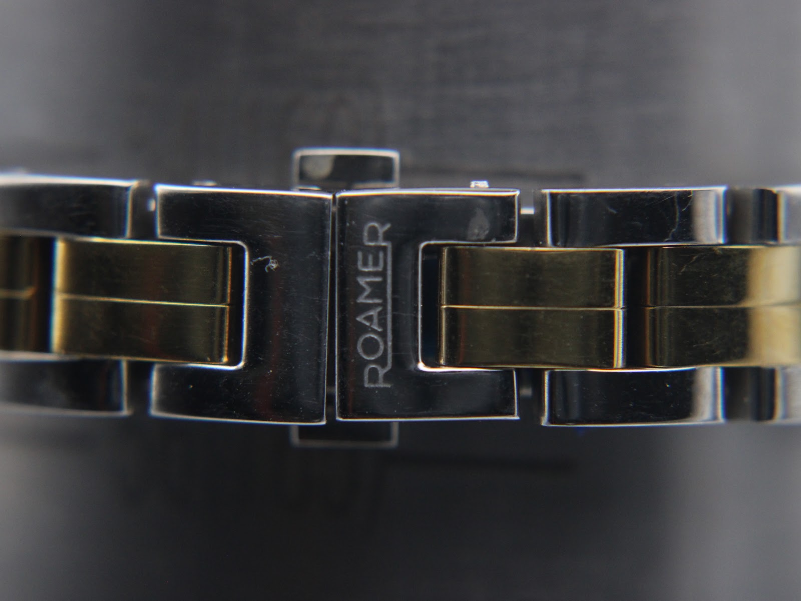 Close-up of the signed Roamer deployment clasp on the two-tone bracelet.