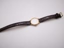 Overhead view of the Tissot C225K watch with the brown leather strap laid flat on a white surface.