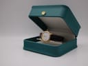 The Tissot C225K watch displayed in an open teal presentation box with a gold crown emblem on the lid.