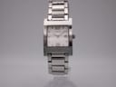 Front view of the Gucci 7700 M watch, featuring a silver square case, white dial with Arabic numerals at 12 and 6, and an integrated stainless steel bracelet.