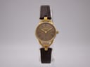Front view of the Gucci 6000L vintage watch on a clear stand, showing the brown dial, gold-tone case, and brown leather strap.