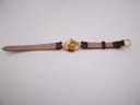 Overhead back view of the Gucci 6000L watch laid flat, showing the case back and the underside of the brown leather strap.