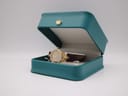 The Gucci 6000L watch resting inside a teal presentation box.