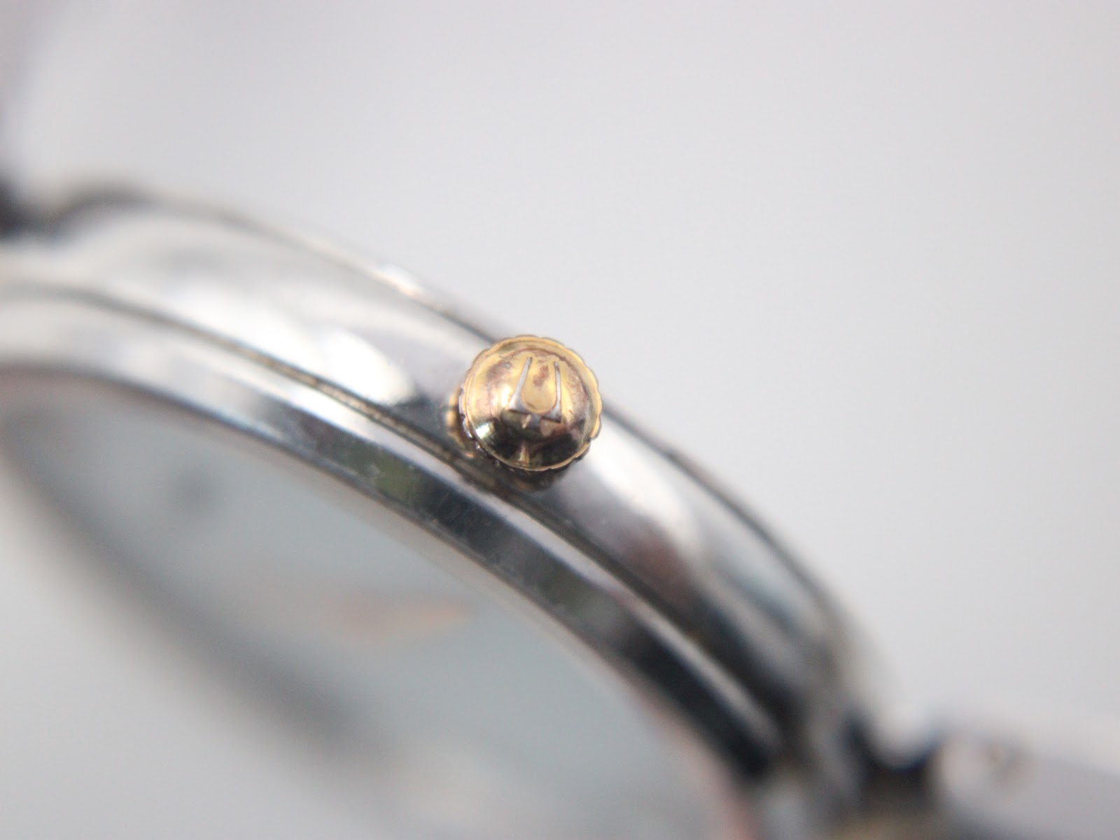 Macro shot of the Bulova watch crown, featuring the distinct tuning fork logo.