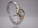 Side-angled view of the Michel Herbelin watch on a stand, highlighting the integrated two-tone bangle and gold-tone bezel.