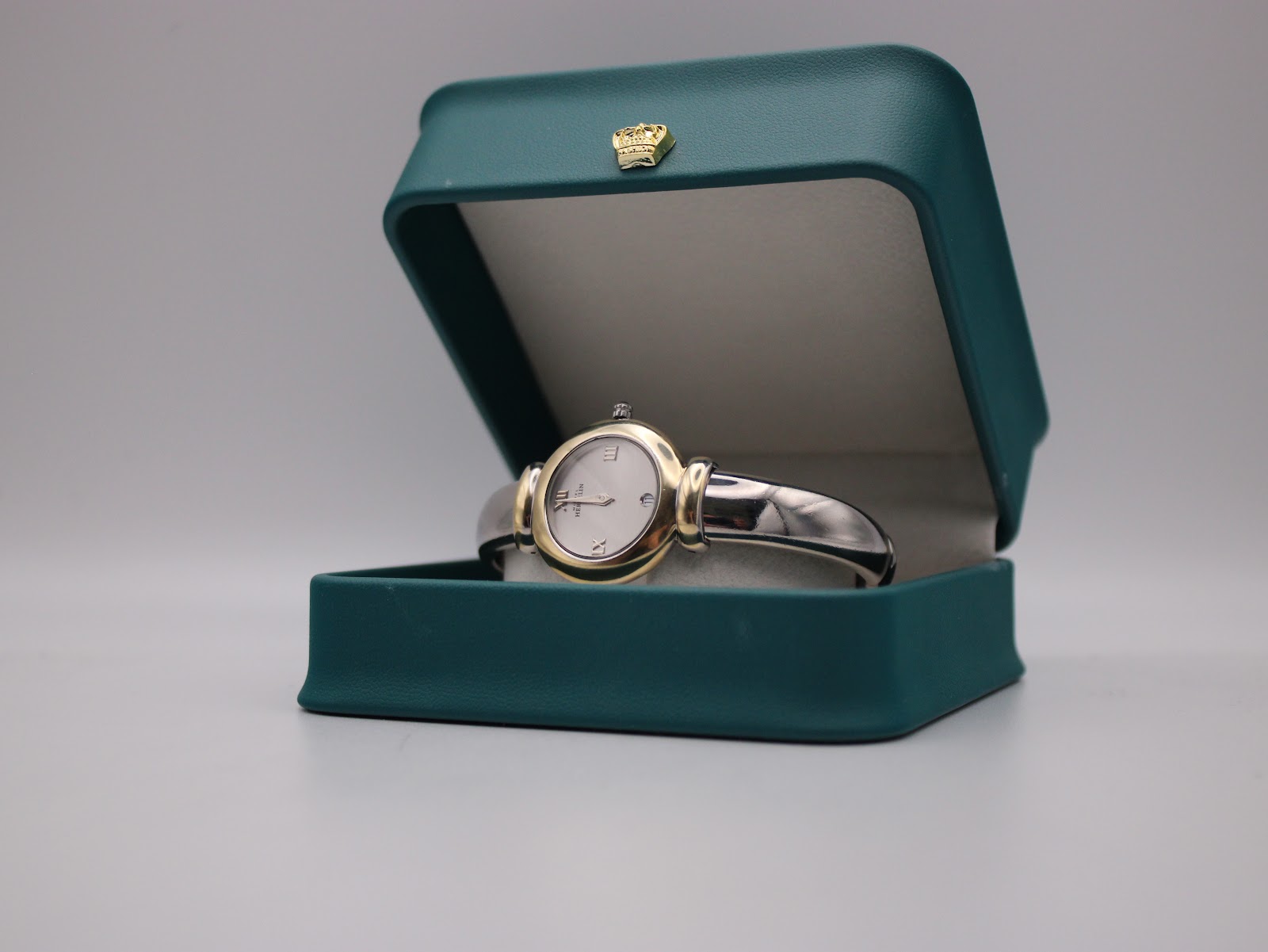 Michel Herbelin watch displayed open in a generic green watch box.