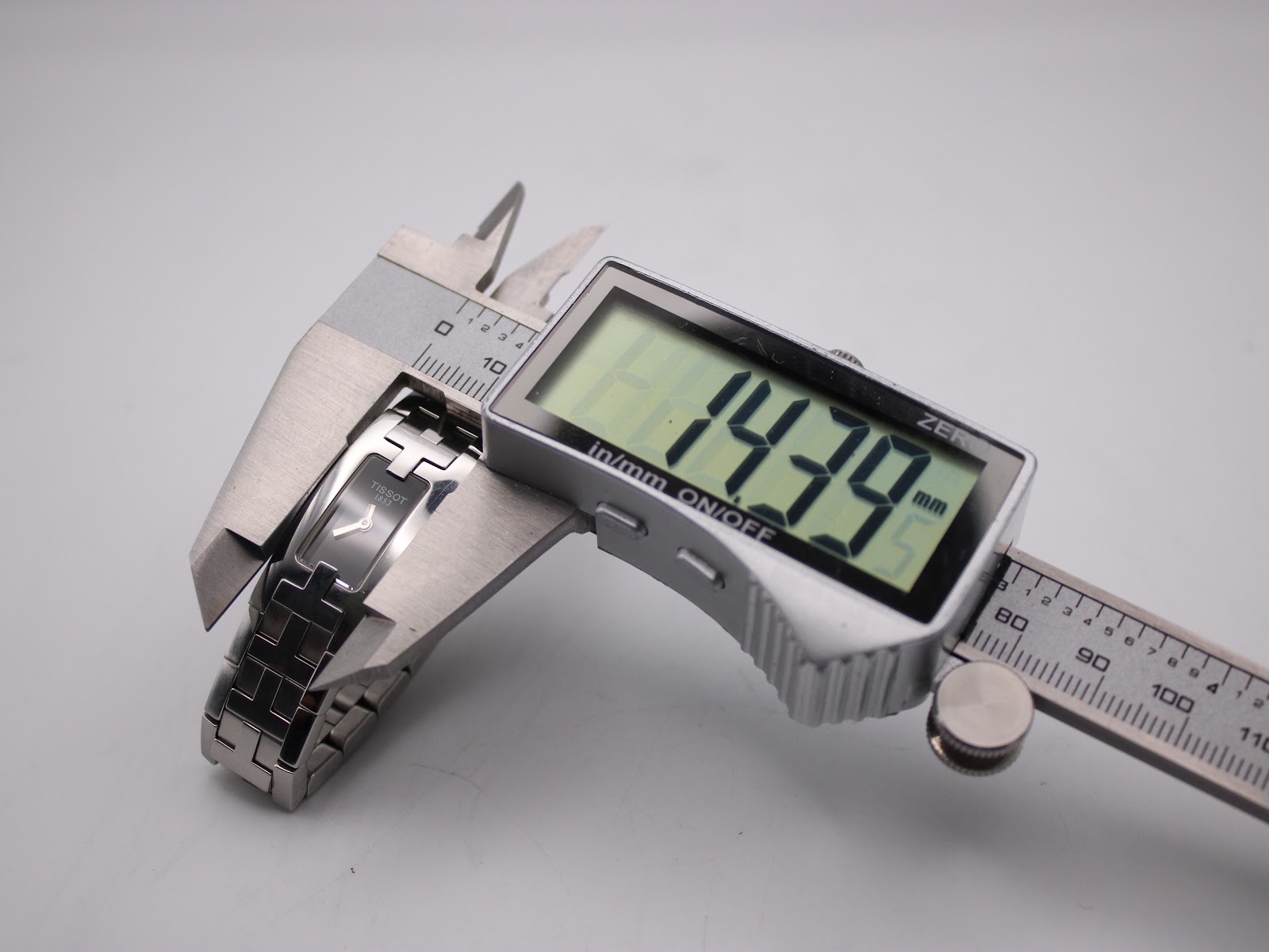 Digital caliper measuring the Tissot L820P case, displaying a precise width of 14.39 mm.