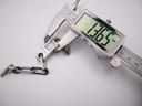 Digital caliper measuring the width of the watch case, displaying a precise measurement of 13.65 mm.