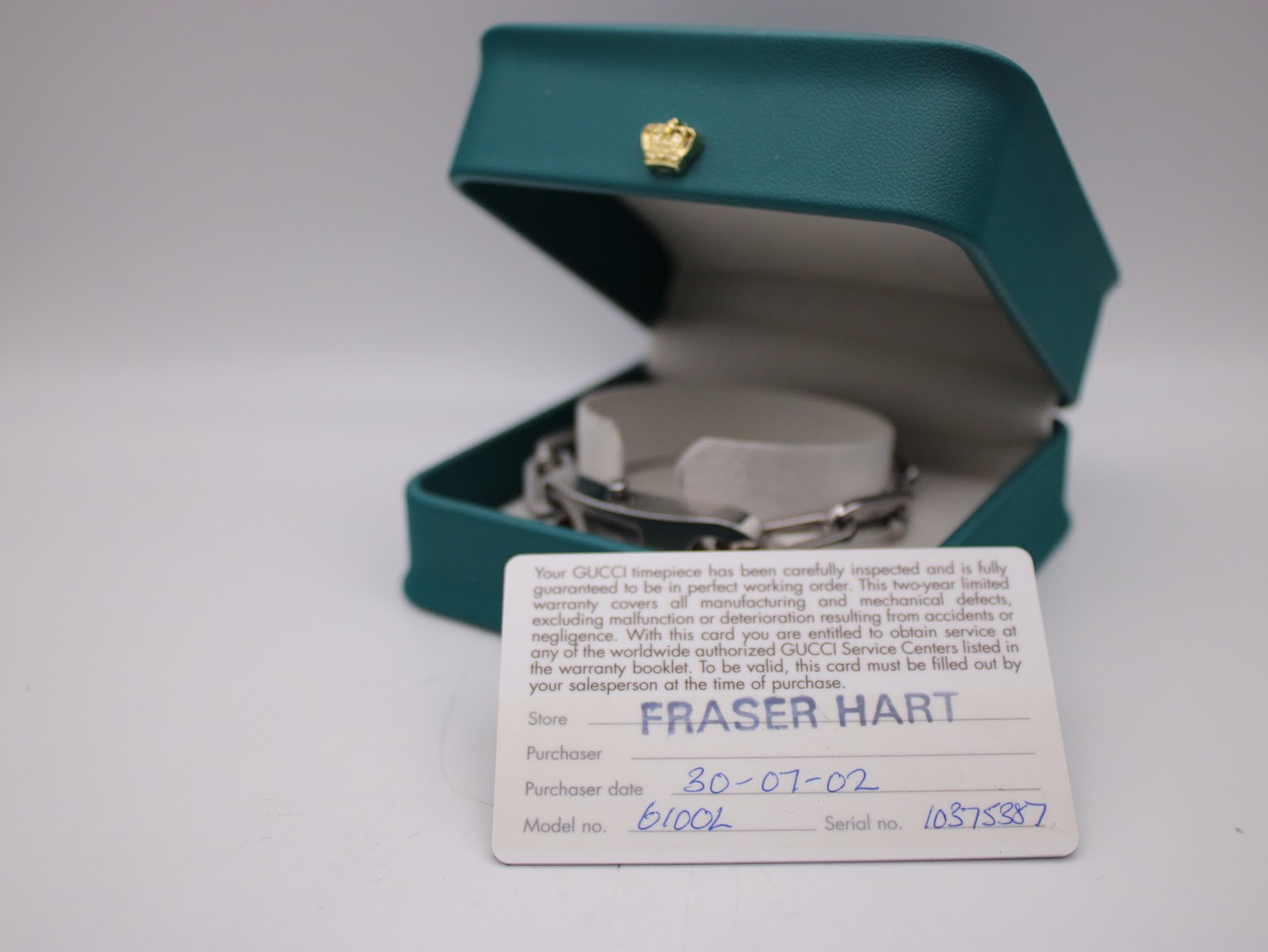 Original Gucci warranty card inside a teal Gucci box, showing the model number, serial number, and purchase date of 30-07-2002.