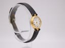 Angled right view of Certina ladies' watch on stand, showing gold case and black leather strap.