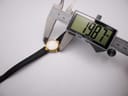 Digital caliper measuring the watch case diameter at 19.87mm.