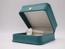 The Michel Herbelin gold watch displayed elegantly inside an open teal presentation box with a cream interior.