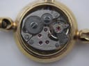Macro view inside the watch, showing the exposed manual wind mechanical movement with visible gears and '17 seventeen jewels' inscription.